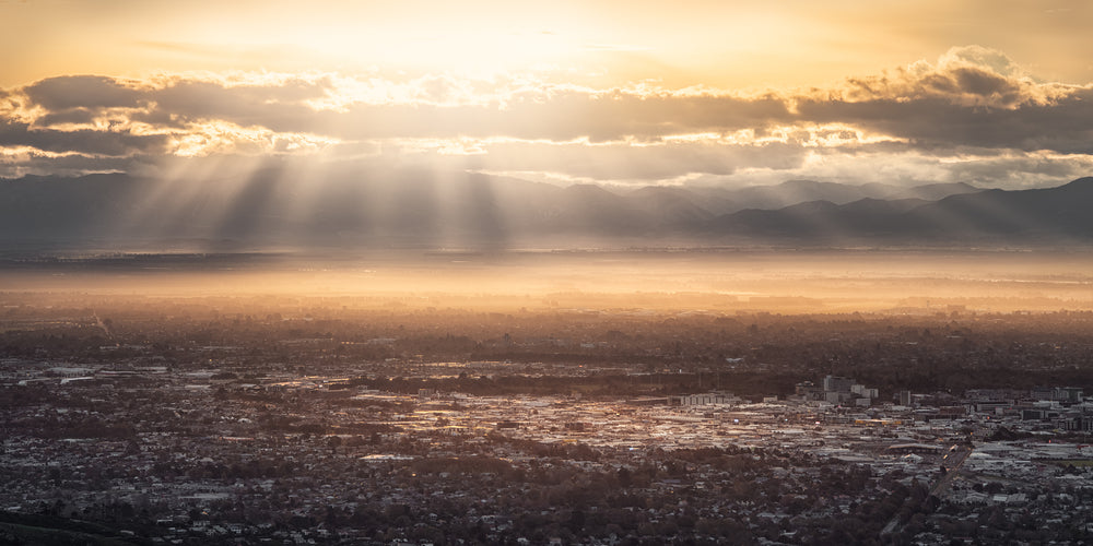 Highly detailed panoramic cityscape photo of Christchurch in the evening, with sunbeams through the clouds