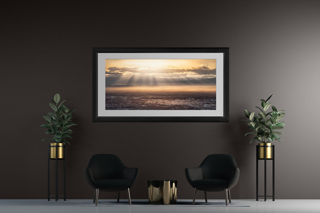 New Zealand landscape framed photo print on a dark wall with two blue chairs and two pot plants