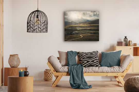 Canvas photo wall art of New Zealand landscape canvas print in lounge setting with a couch, cushions, coffee tables, and pendant light.