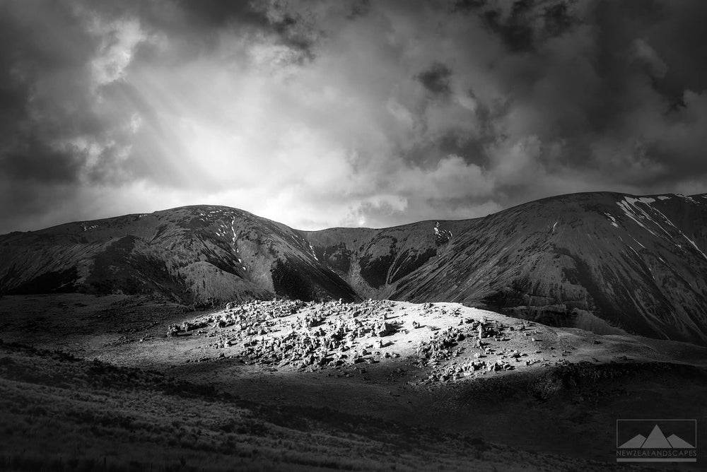 image of rocks on a hill at Castle Hill lit up by the setting sun behind white clouds