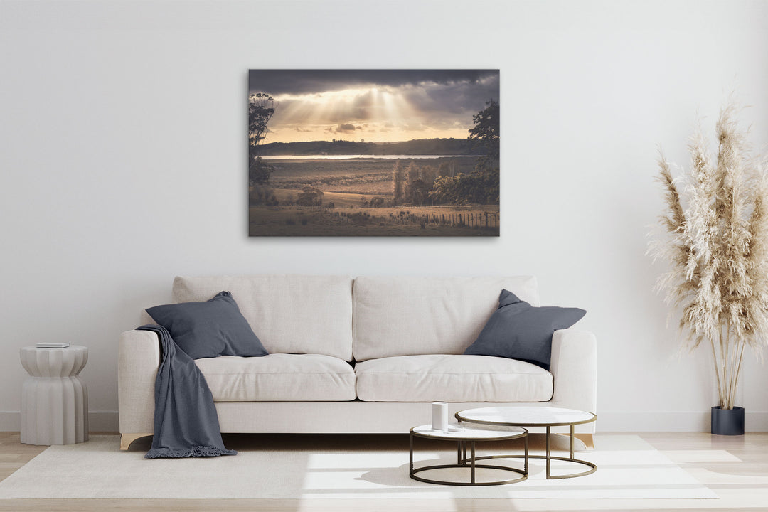 New Zealand landscape photo canvas wall art in neutral lounge setting with a white couch, cushions, coffee tables and plant