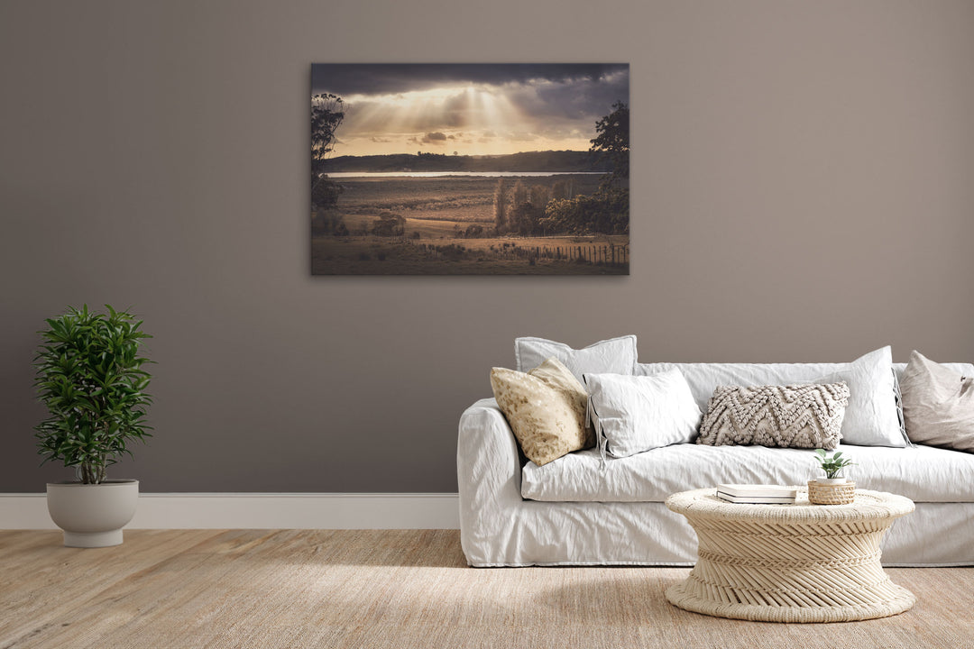 Canvas photo wall art of New Zealand landscape image  in lounge setting with a grey wall, white couch, coffee table, plant, cushions