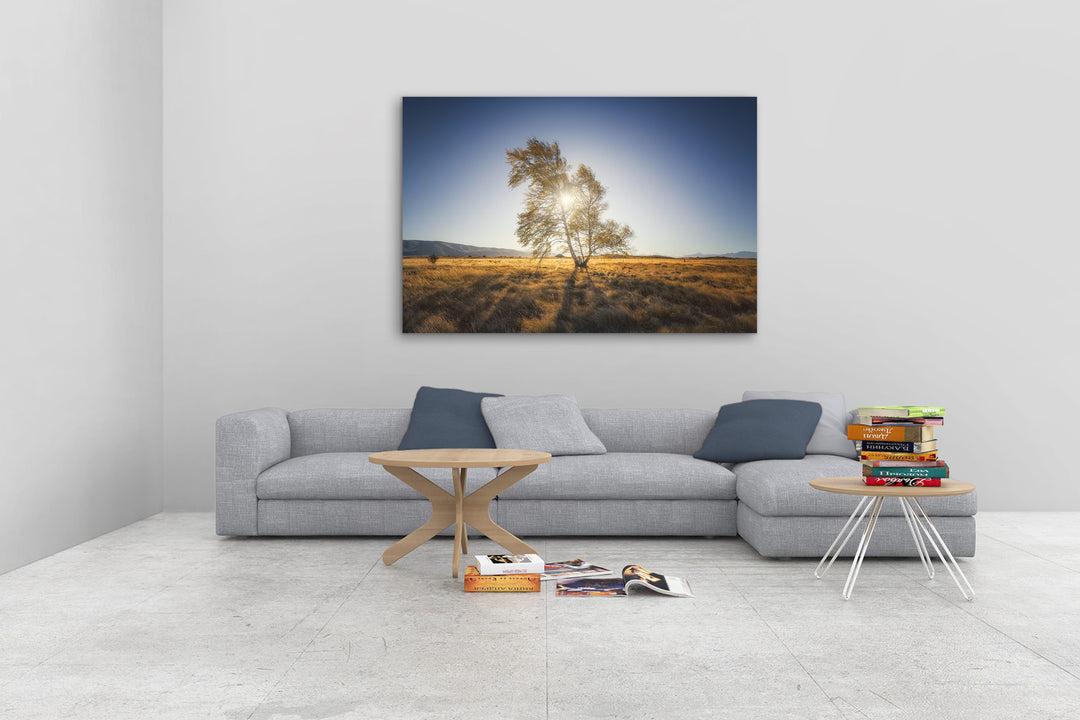 New Zealand landscape photo canvas wall art in neutral lounge setting with a grey couch, coffee tables and books