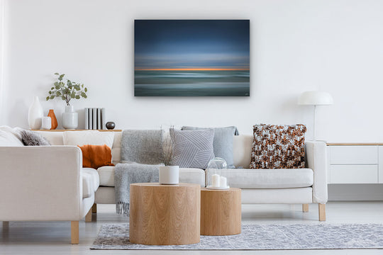 Canvas photo wall art of New Zealand landscape in neutral lounge setting with a white couch, cushions, coffee tables and plant