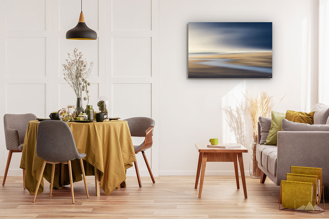 New Zealand landscape on canvas on a wall in a dining room with dining table & chairs, couch, coffee table & plants