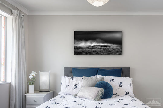 Fine art panoramic black and white canvas of crashing waves on the wall of a bedroom