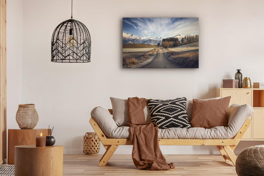 Canvas photo wall art of New Zealand landscape canvas print in lounge setting with a couch, cushions, coffee tables, and pendant light.