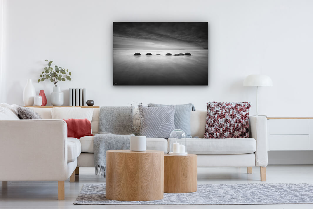 Canvas print on a modern lounge wall of black and white Moeraki boulders
