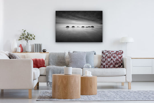 Canvas print on a modern lounge wall of black and white Moeraki boulders