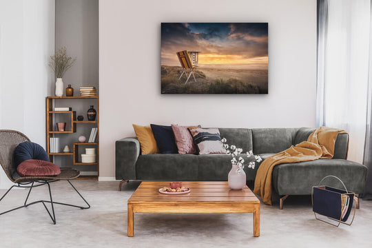 Canvas wall art of landscape photo print with a grey couch, plant, chair and table.