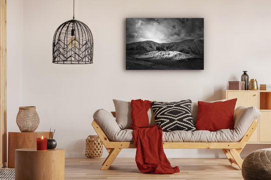 Canvas photo wall art of New Zealand landscape canvas print in lounge setting with a couch, cushions, coffee tables, and pendant light.