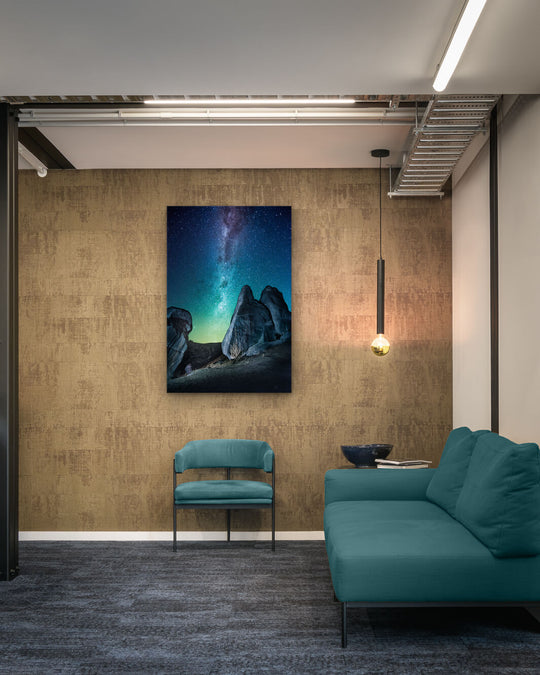 Canvas photo of New Zealand landscape on the wall of an industrial office with couch, chair and pendant light.