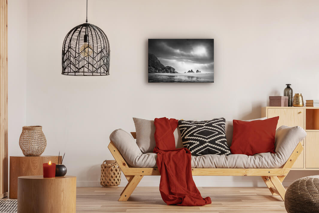 Canvas photo wall art of New Zealand landscape canvas print in lounge setting with a couch, cushions, coffee tables, and pendant light.