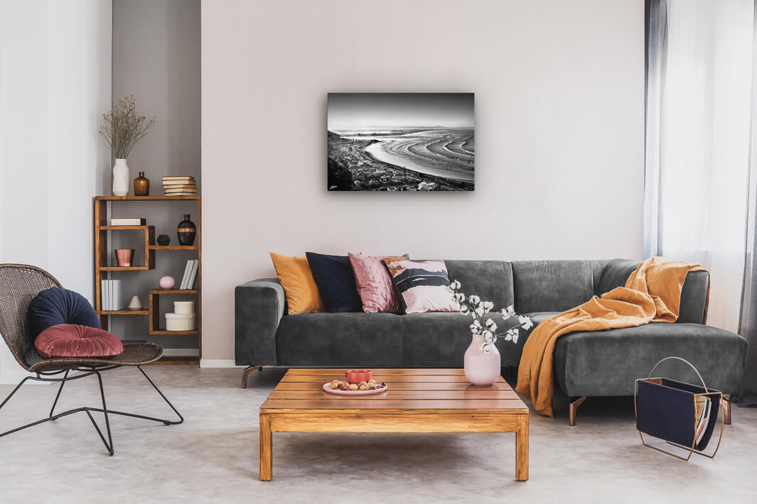 Canvas wall art of landscape photo print with a grey couch, plant, chair and table.