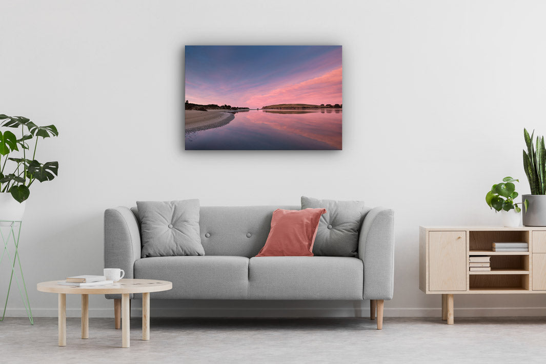 Sofa couch, plants, wooden furniture and landscape photo wall art on display.