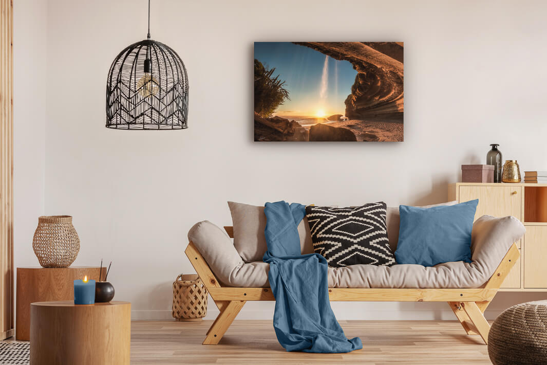 Canvas photo wall art of New Zealand landscape canvas print in lounge setting with a couch, cushions, coffee tables, and pendant light.