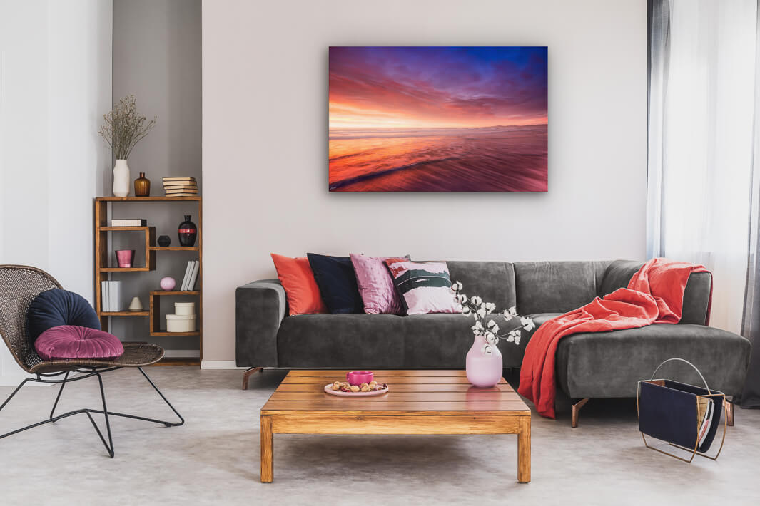 New Zealand landscape photo canvas wall art in neutral lounge setting with a grey couch, coffee tables and books