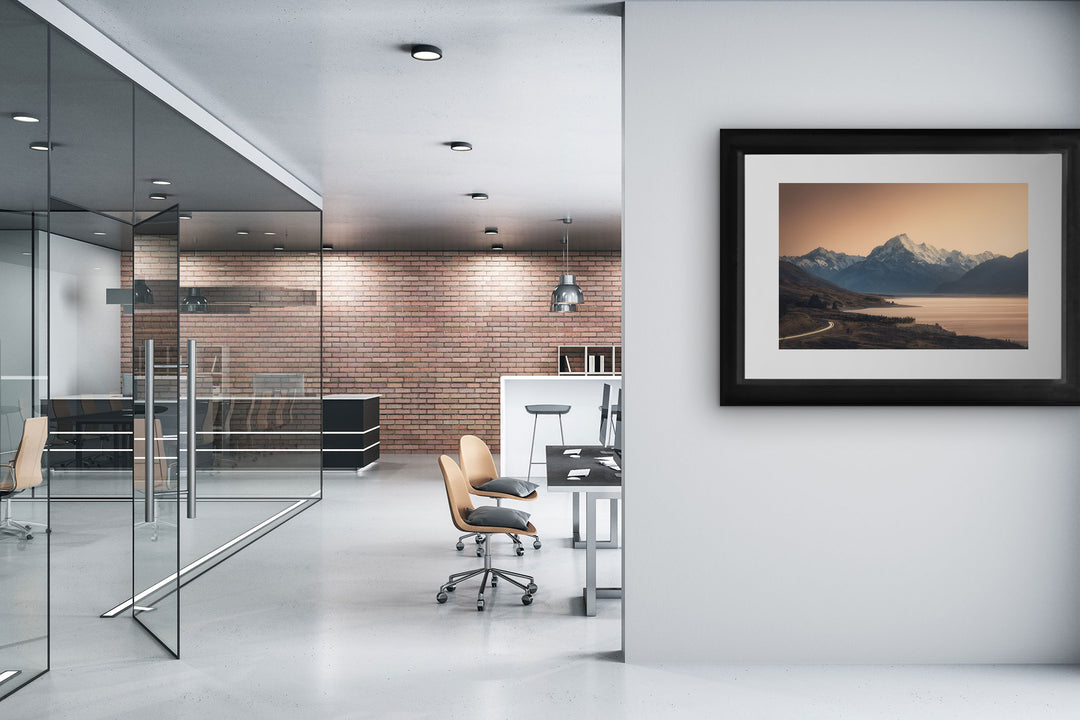 Framed photo of Mount Cook mountains on the wall of an office with desks and chairs