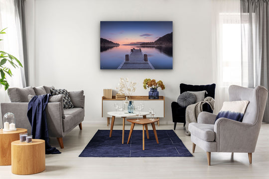 New Zealand landscape photo wall art in neutral lounge setting with a couch, rug, plant, flowers, chair and curtains