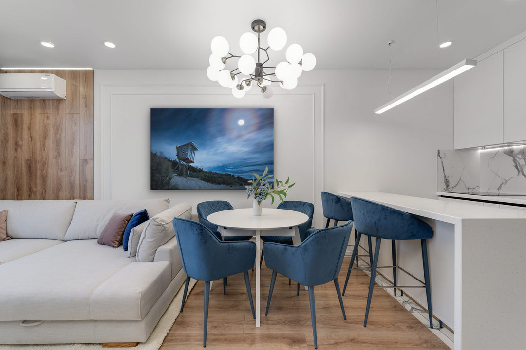 New Zealand landscape photo on canvas in modern kitchen with white bench, neutral couch and blue accents