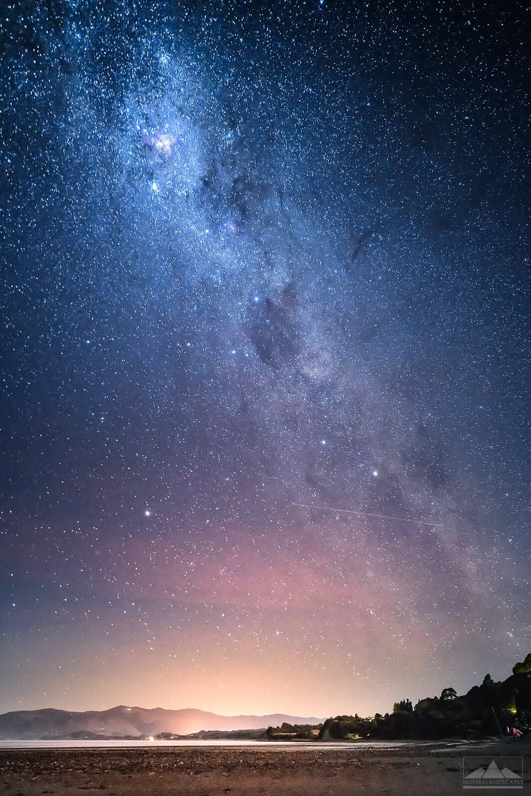 Milky Way night sky photograph with Golden Bay hills, sea and beach below