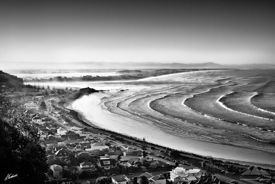 coastline photo of Sumner beach and village with mountains in the distance.
