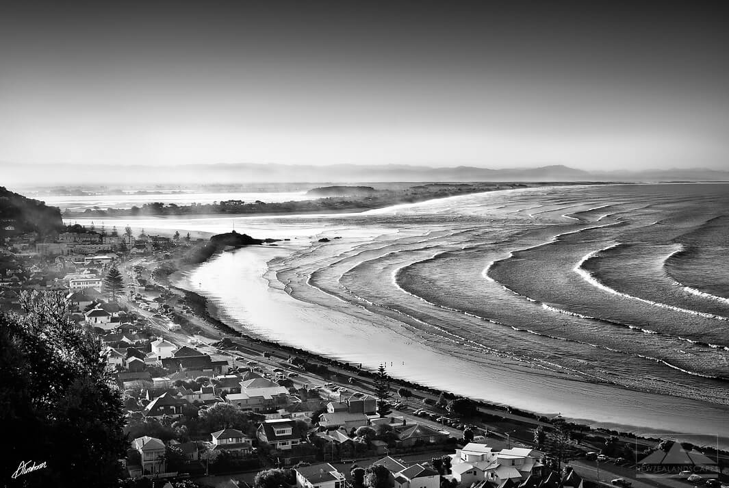 coastline photo of Sumner beach and village with mountains in the distance.