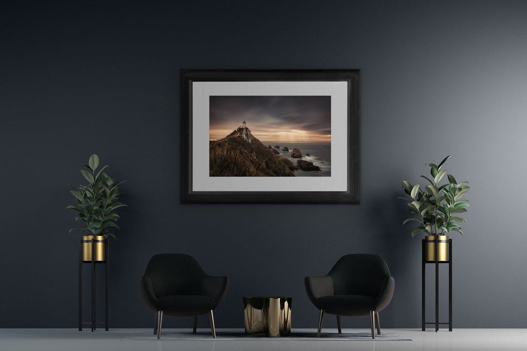 New Zealand landscape framed photo print on a dark wall with two blue chairs and two pot plants