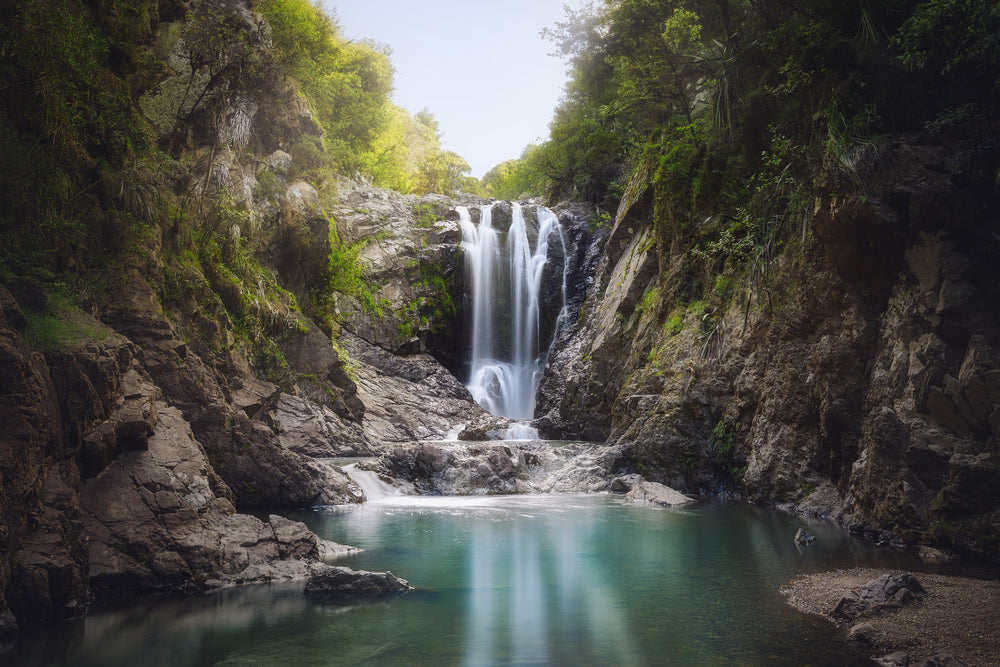 Piroa Falls waterfall near Waipu in Northland New Zealand surrounded by native bush with a calm pool below