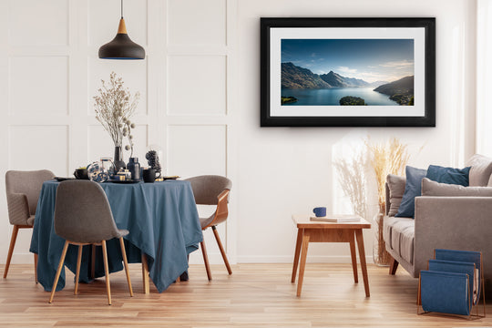 Framed landscape photograph of Lake Wakatipu in Queenstown featured in a dining room, adding a peaceful New Zealand alpine lake view to a warm and inviting interior space.