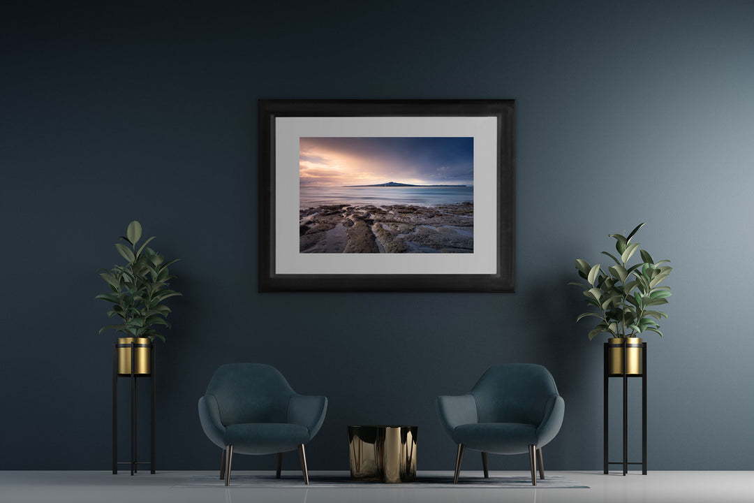 New Zealand landscape framed photo print on a dark wall with two blue chairs and two pot plants