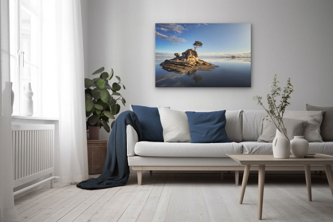 Canvas photo wall art of New Zealand landscape in neutral lounge setting with a white couch, cushions, coffee table and plants