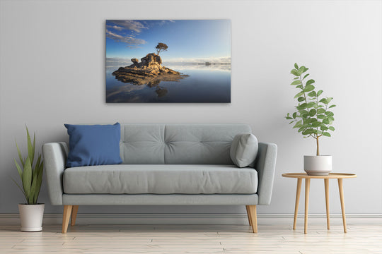 Canvas photo wall art of a New Zealand landscape with a grey couch, plants and table.