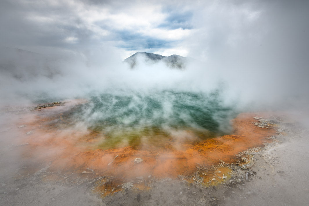 Photograph of a geothermal area in New Zealand showing the different coloured thermal water and steam