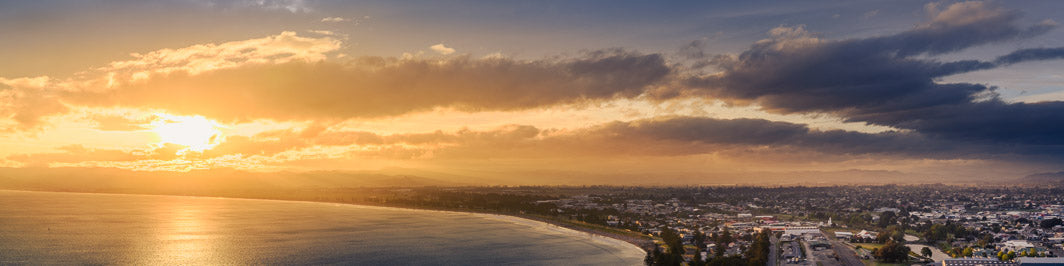 Panoramic landscape photo of Gisborne city at sunset looking down over the city and the seaside
