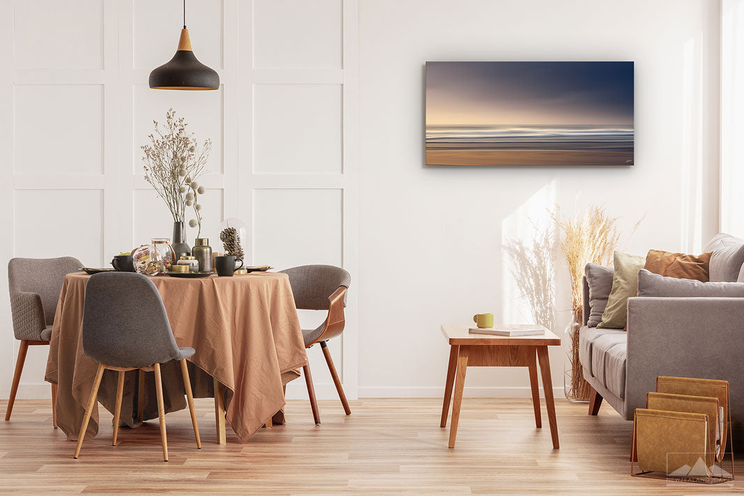 New Zealand landscape on canvas on a wall in a dining room with dining table & chairs, couch, coffee table & plants