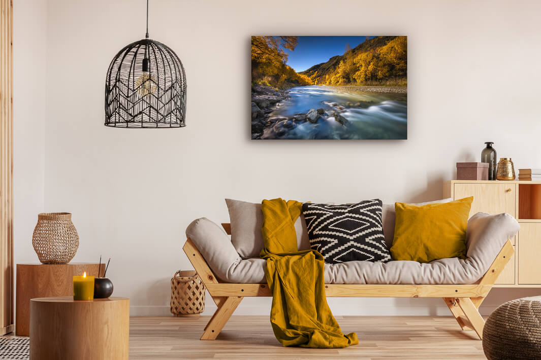 Sitting room with photo print of Arrowtown, Otago during autumn. Bright blue sky complements the yellow trees.