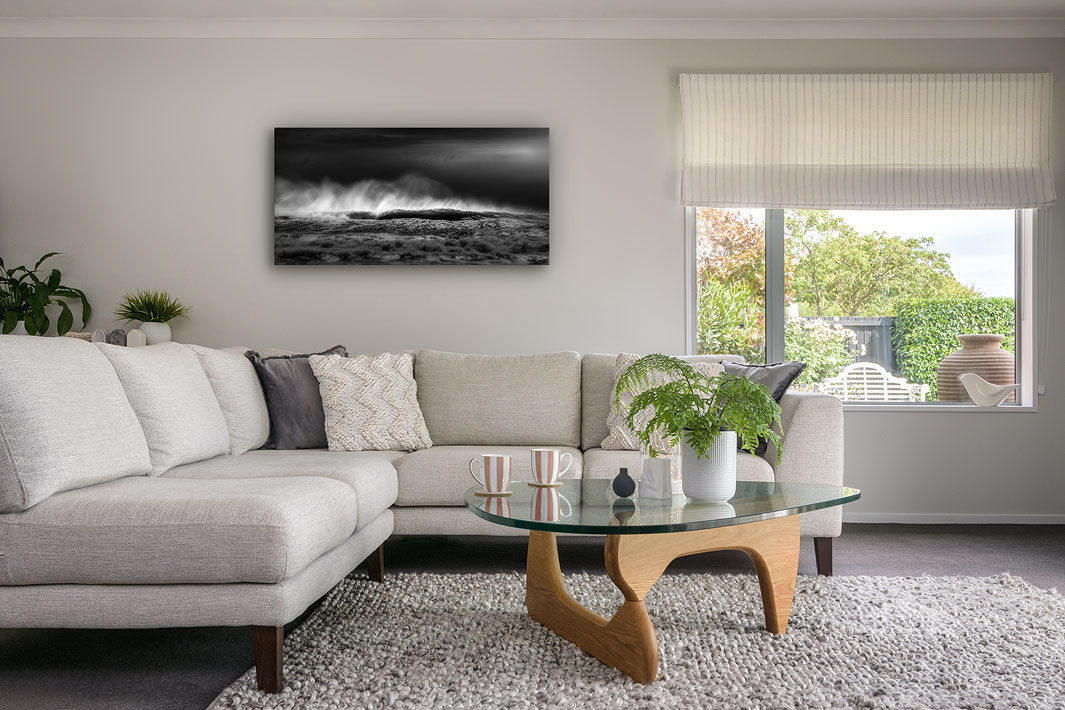 Fine art panoramic black and white canvas of crashing waves on the wall of a modern living room