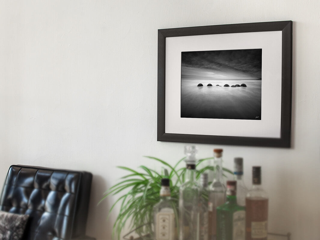 Fine art black and white photo print framed showing the Moeraki boulders in a row