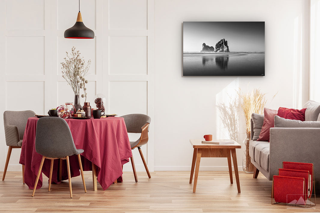 Fine art black and white photo print showing the Archway Island rocks at Wharariki Beach, displayed on a dining room wall