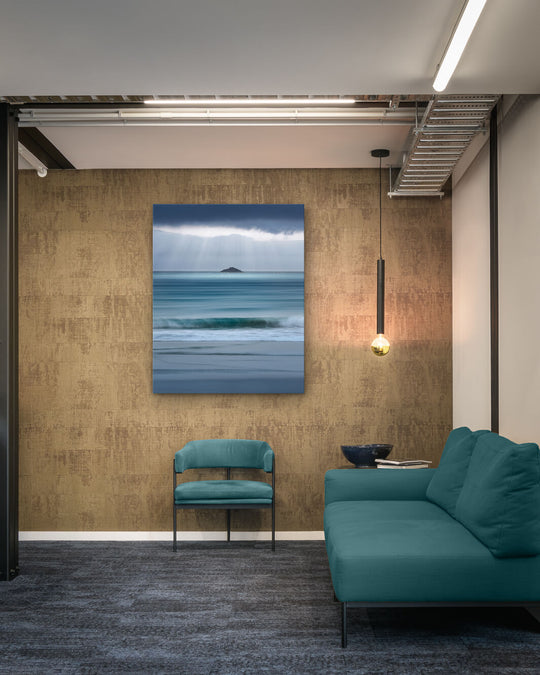 Canvas photo of New Zealand landscape on the wall of an industrial office with couch, chair and pendant light.