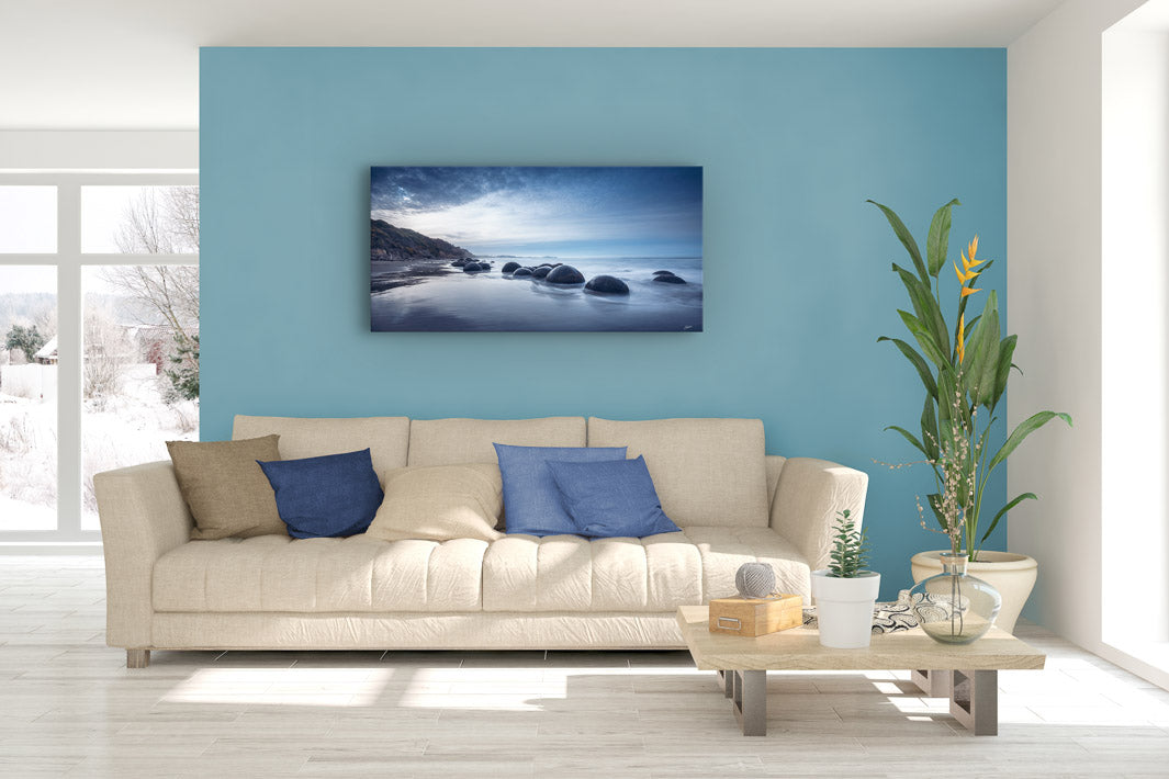 Lounge suite with soft furnishings and plants, with a large photographic canvas wall print.