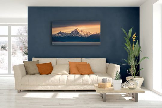 New Zealand landscape canvas photo wall art in lounge setting with a blue wall, white couch, coffee table, plant, cushions