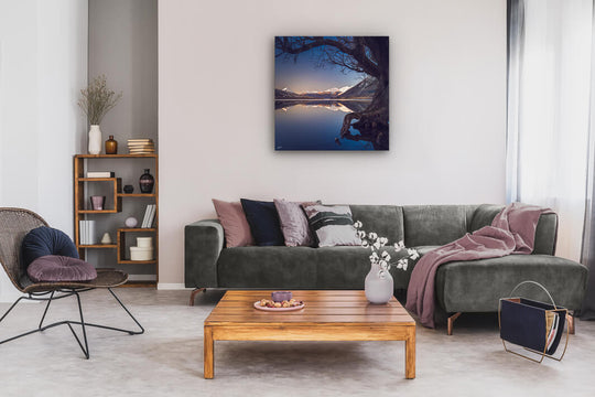 Canvas photo wall art of a New Zealand landscape with a grey couch, plants, chair and table.