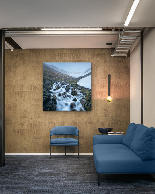 Canvas photo of New Zealand landscape on the wall of an industrial office with couch, chair and pendant light.