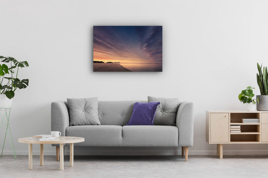 Stunning sunrise photographic wall art on display above a neutral modern couch and occasional furniture.