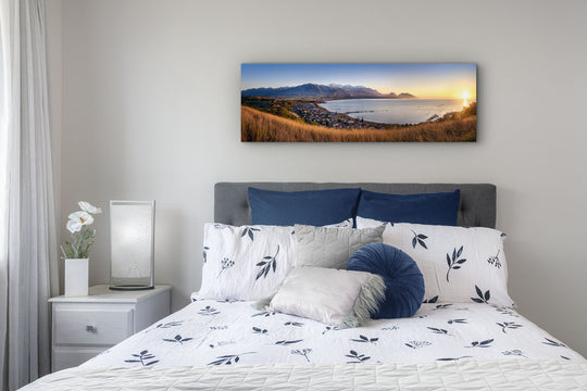 Canvas wall art of New Zealand landscape photo print in a white walled bedroom with headboard, drawer, lamp & curtain