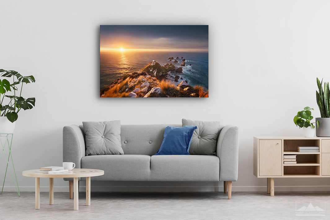 Canvas wall art photo on a lounge wall of the sunrise at Nugget Point lighthouse in Otago, New Zealand