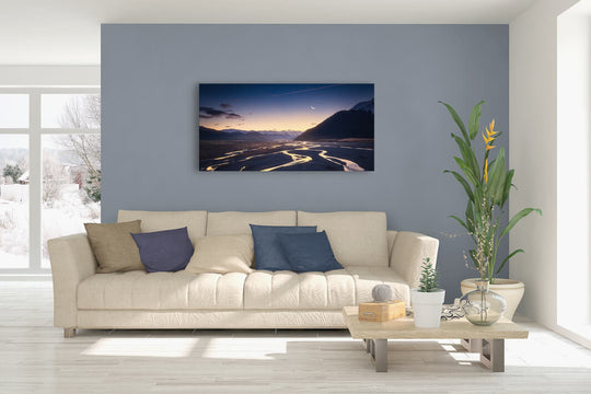 New Zealand landscape canvas photo wall art in lounge setting with a blue wall, white couch, coffee table, plant, cushions