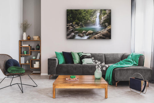 Canvas wall art of landscape photo print with a grey couch, plant, chair and table.
